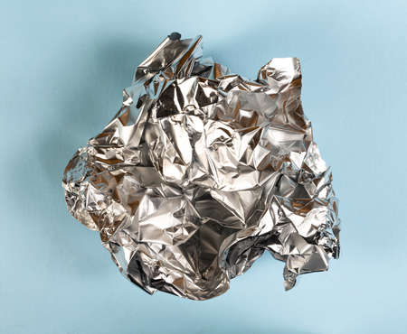 the tinfoil crumpled onto a colored surfaceの写真素材