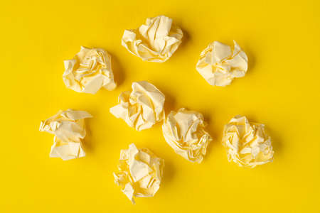 some crumpled pieces of paper on a yellow surfaceの写真素材