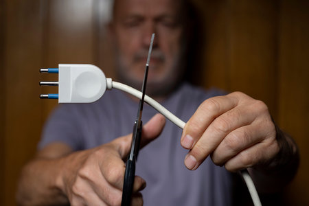 a man while cutting the electric wire with scissorsの写真素材