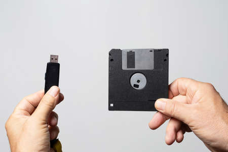 the comparison between an old floppy disk and a USB key for data storageの写真素材