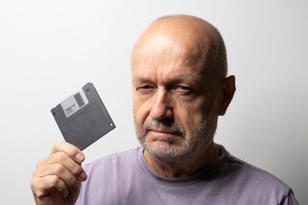 a man with an old floppy disk in his handの写真素材