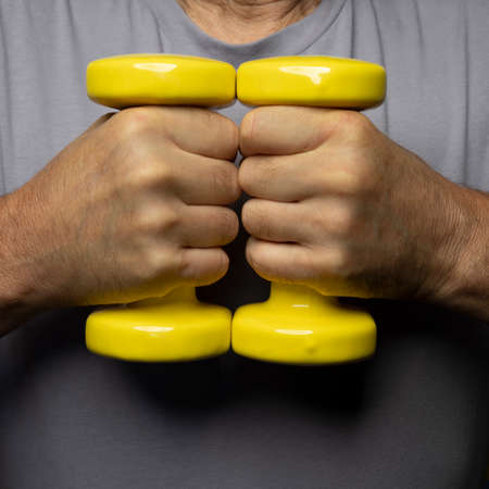 yellow gymnastic weights in handの写真素材