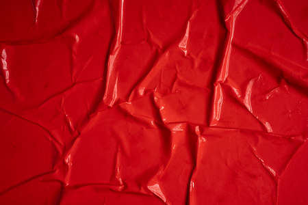 Red background. Wet and wrinkled sheet of paper. Background mockup.の写真素材