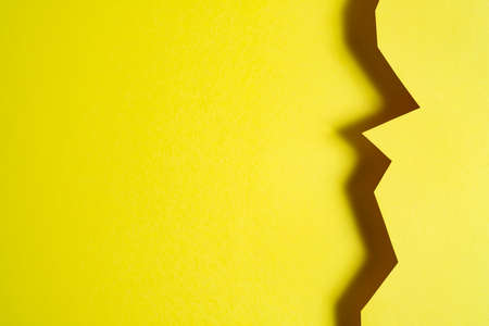 a yellow background formed with the shadow of a cut cardの写真素材