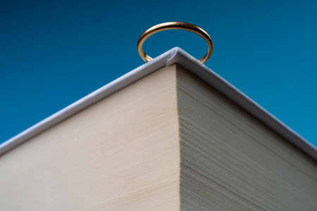 a wedding ring poised on the edge of a book