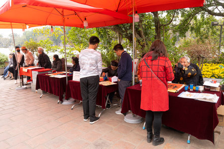 Hanoi, Vietnam. Jnauary 2023. Man on the street writing auspicious words on red signs during Chinese New Year eveのeditorial素材
