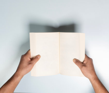an empty book in the hands of a man on a white backgroundの写真素材