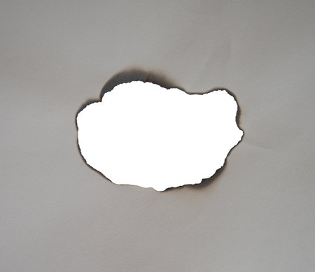 a scorched sheet of paper on a transparent surfaceの写真素材