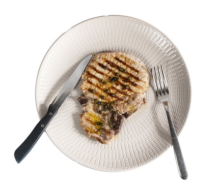 a grilled pork chop seasoned with oil and green peppercornsの写真素材