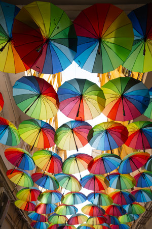 Bucharest, Romania. May 23, 2024. Multicolored umbrellas ceiling in a narrow street of the city...