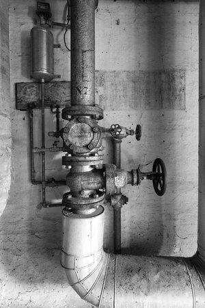 old pipes with measuring and control instruments in an abandoned industrial structureの写真素材