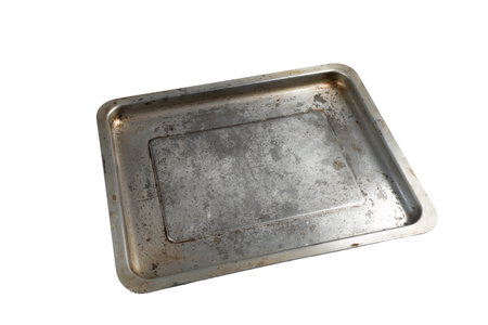an old dirty and scratched metal pan on a transparent surface