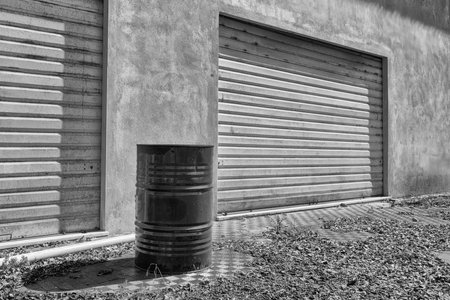 a metal bin outside an old abandoned industrial structureの写真素材