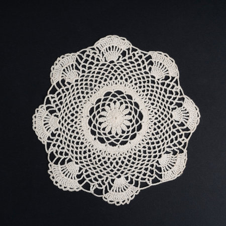 a crocheted doily on a black background