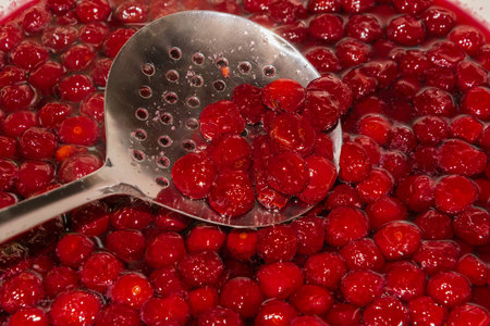 cooking cherry jam on a gas stove in the villageの写真素材