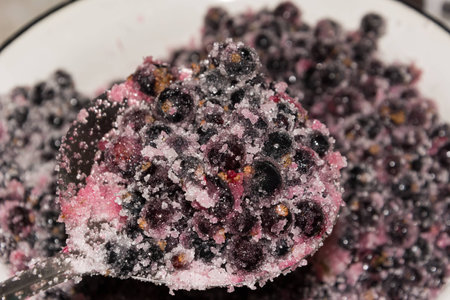 cooking black currants jam in the rural kitchen の写真素材