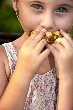 the little girl on a bench eats a big pearの写真素材