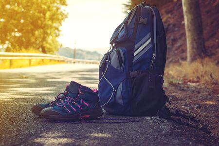 boots and backpack of the tourist have been photographed on the road
