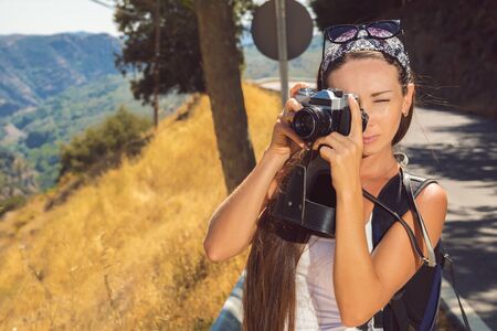 the beautiful girl the traveler with the camera has been photographed on walk in mountainsの写真素材
