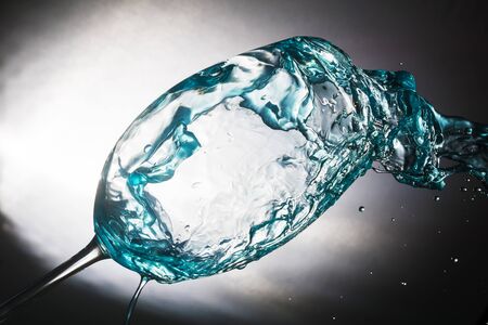 Beautiful spray colored water in a glass were photographed in the studioの写真素材