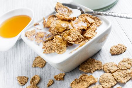 Sweet delicious cereal flakes with milk and honey were photographed for breakfast