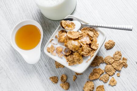 Sweet delicious cereal flakes with milk and honey were photographed for breakfast
