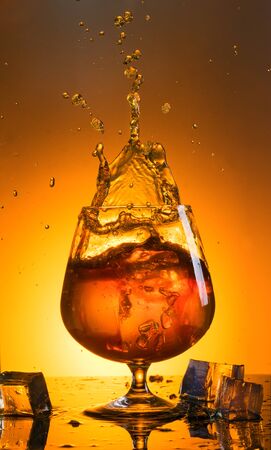 A large glass of whiskey with sprayの写真素材