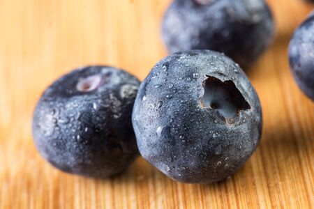 Beautiful fresh blueberry in white plate photographed against wooden backgroundの写真素材