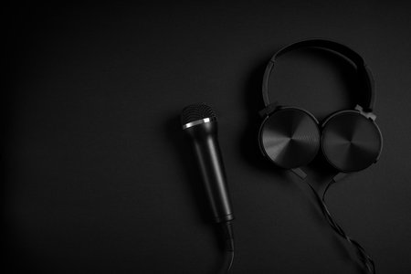 black microphone and headphones on a black backgroundの写真素材