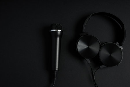 black microphone and headphones on a black backgroundの写真素材
