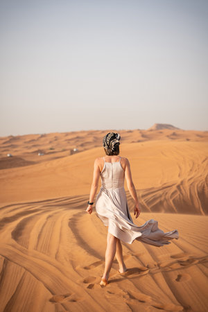 Beautiful girls in a beautiful flowing dress in desert conditionの写真素材