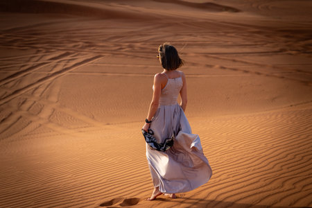 Beautiful girls in a beautiful flowing dress in desert conditionの写真素材