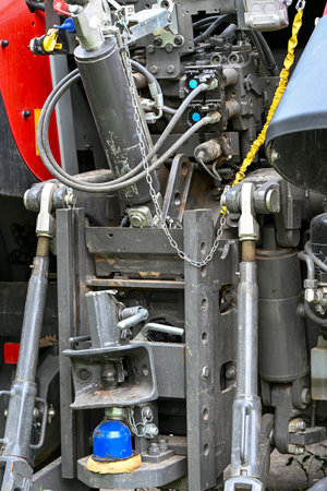 Detailed view of the rear hydraulic and mechanical system of a modern tractor, showing hoses, joints, and connectors used for agricultural machinery attachmentsの写真素材