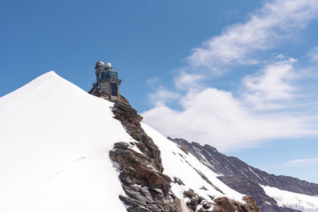 The Sphinx Observatory at Jungfraujoch in the Bernese Alps, Switzerland. Perched on a rocky ridge surrounded by snow and glaciers, it is one of the highest research stations and tourist attractions in Europeの写真素材