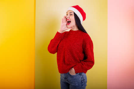 Young girl shouting over yellow background.の写真素材