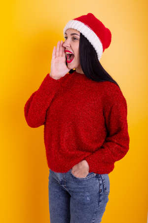 Young beautiful girl shouting over yellow background.の写真素材