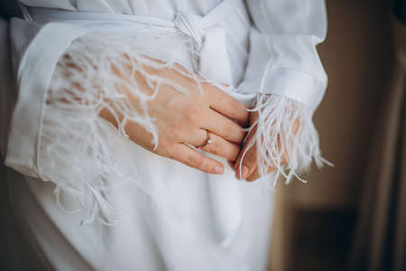 the bride holds a gold wedding ring with a diamondの写真素材