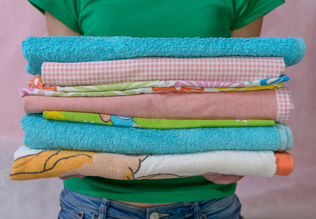 Woman holding folded clothes in hands. Closeupの写真素材