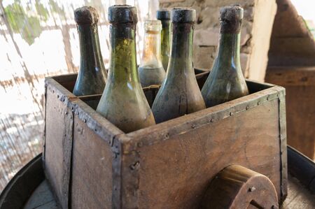 Box with old and dusty bottles of wine