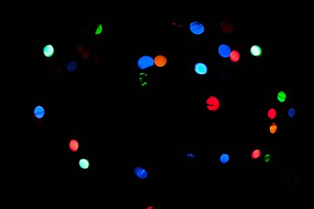 Colorful lights red, green, white and blue out of focus in the darkの写真素材