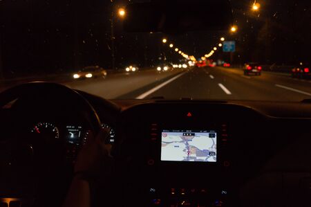 Driving car at night with navigator with rainの写真素材