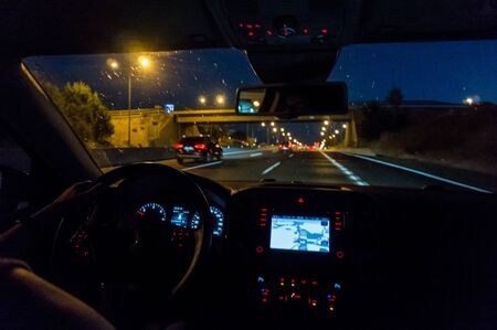Driving car at night with navigator with rainの写真素材