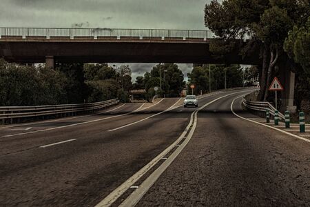 Car on the road with bridge and traffic signs