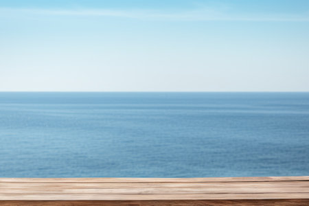 Wooden table on the backdrop of a blue sea, white sand beach, clear blue sky. Space for product or object presentation.の素材