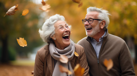 Happy senior couple walking in autumn park. They are laughing and having funの素材