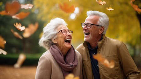 Happy senior couple having fun in autumn park. They are laughing and looking at cameraの素材