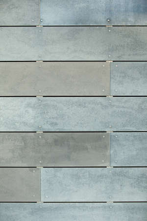 Image of a wall clad with ventilated facade cement tiles. House wall cladding technology. Gray shades background for banner.の写真素材