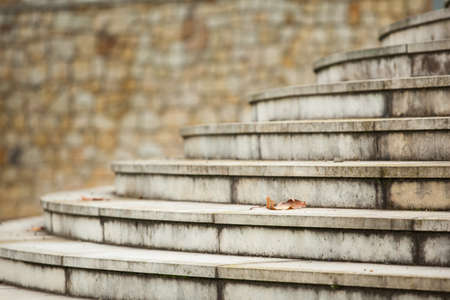 An image of a stone staircase with steps climbing diagonally in the frame against a blurred...