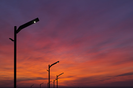 Modern street lights on a curb at sunsetの写真素材