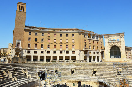 Roman amphitheater with Sedile palace and the column with Sant'Oronzo statue in Lecce Sant'Oronzo square, Apulia, Italyのeditorial素材